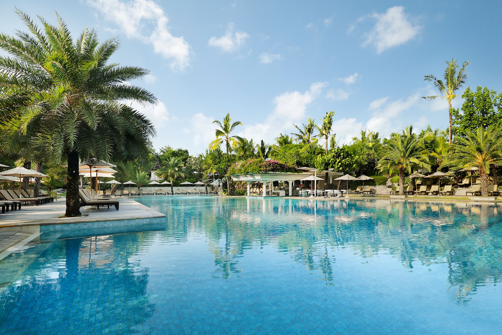 Large lagoon pool with palm trees at Padma Resort Legian