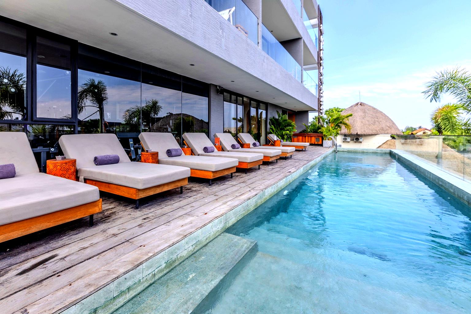 Long swimming pool with sun loungers at Sunny Aparts II