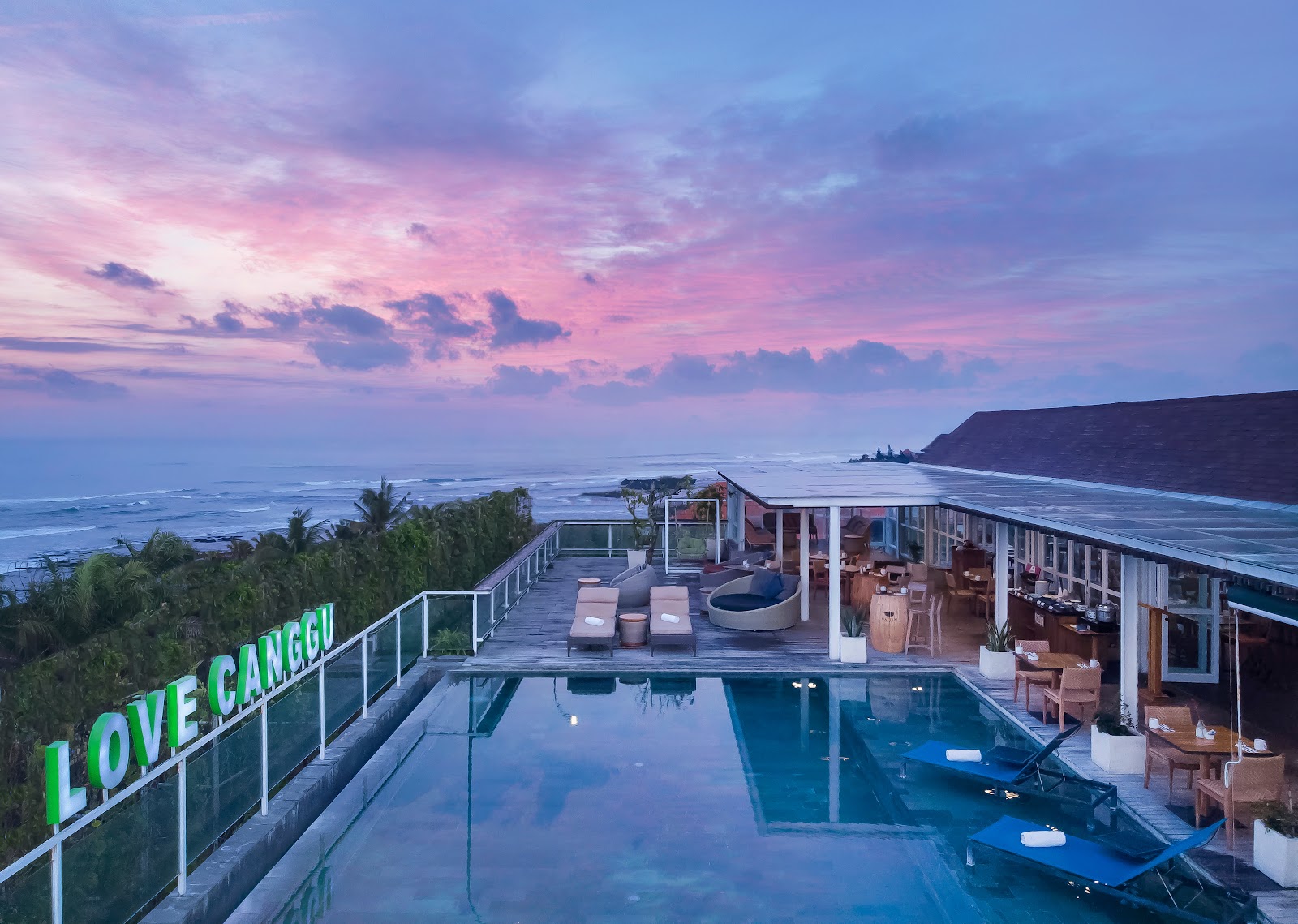 Pool and beachfront buildings at sunset at ASTON Canggu Beach Resort