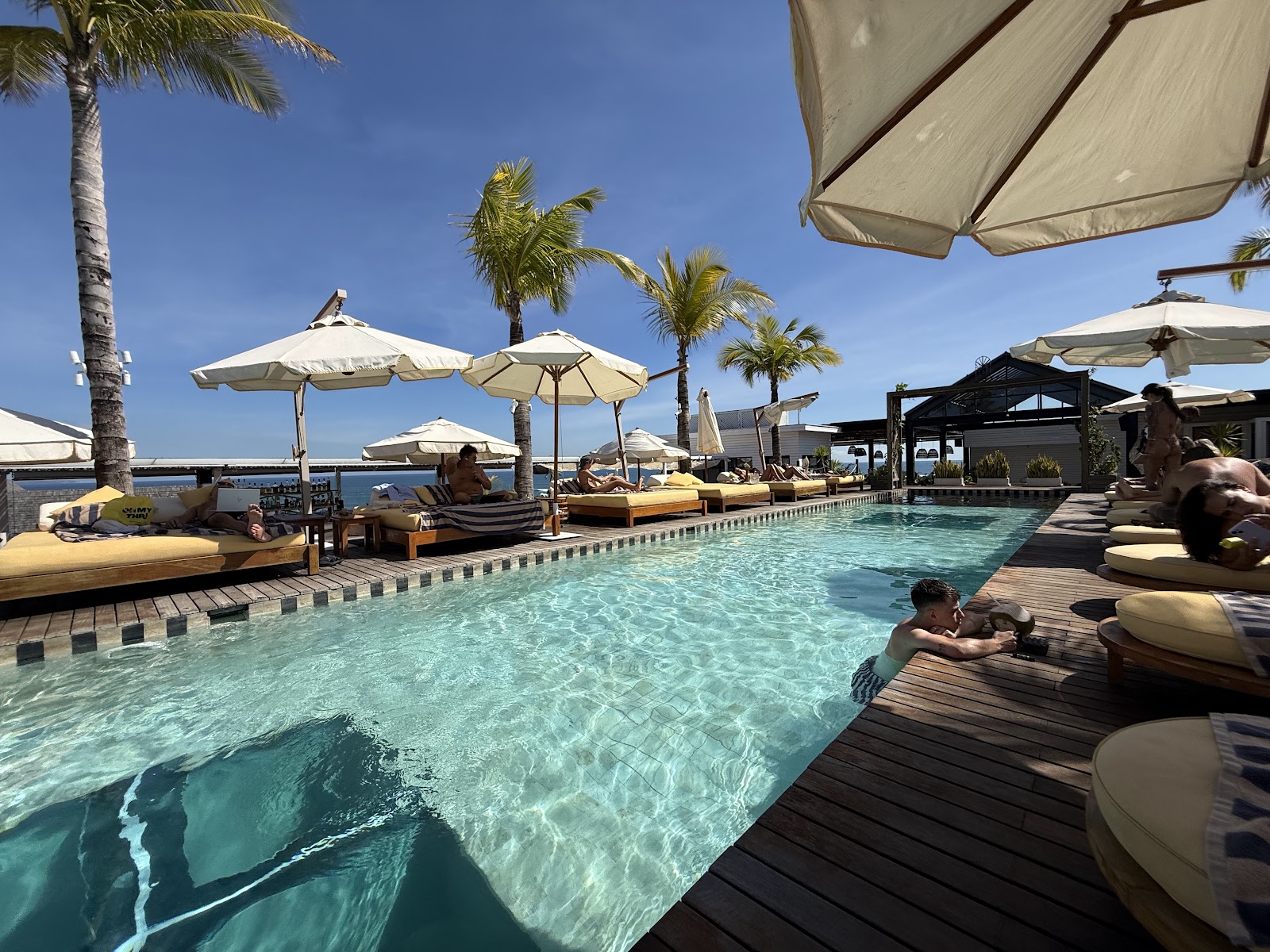 Rooftop pool with sun umbrellas at Secana Beachtown in Berawa