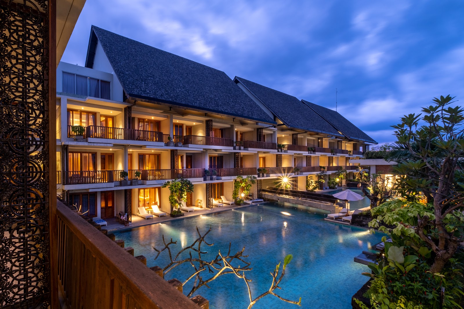 Swarga Suites Bali Berawa building and pool lit up at dusk