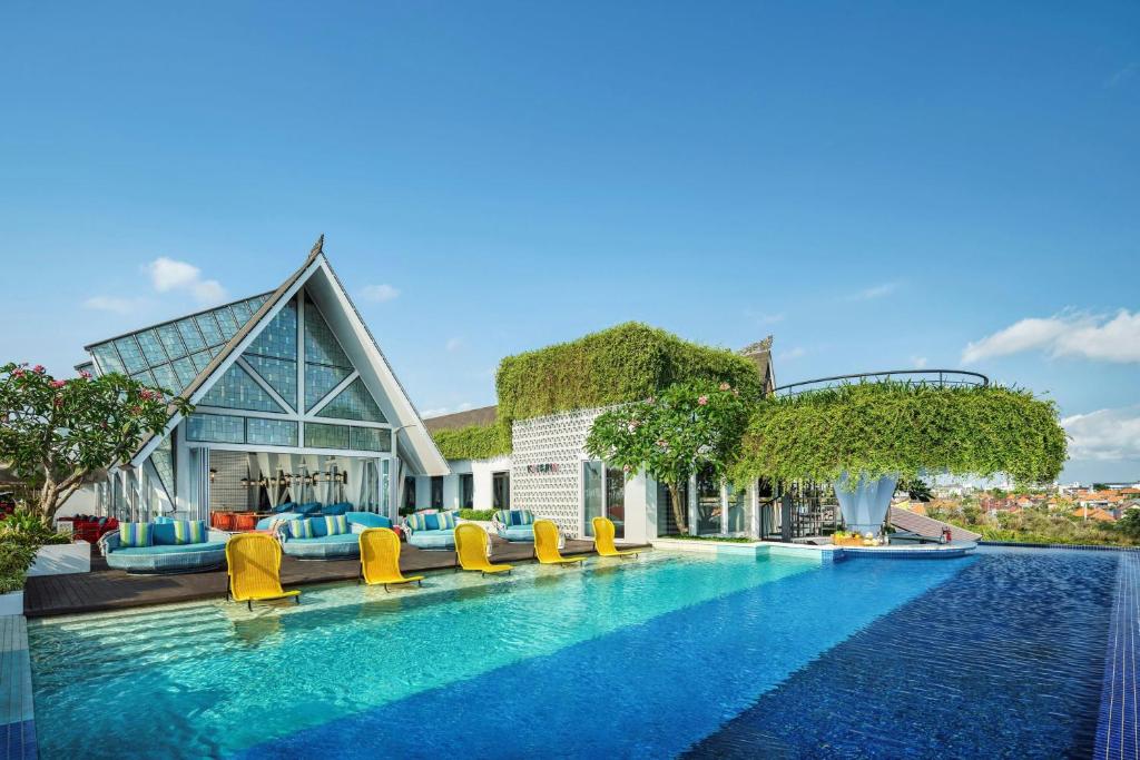 Swimming pool and resort buildings at Aloft Bali Seminyak