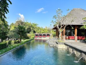 Tropical resort pool with thatched pavilions in Canggu